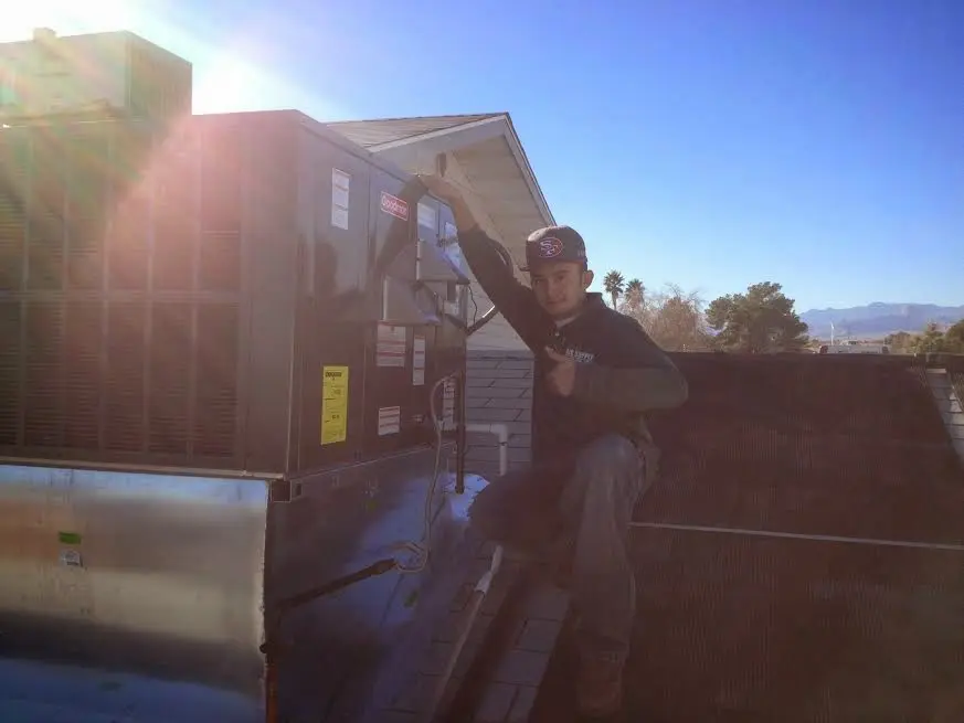 HVAC technician performing AC Tune-Up on a rooftop unit in West Goshen